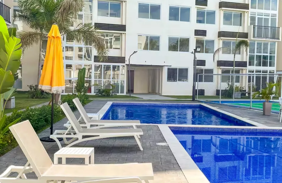 Pool with sun loungers and umbrella at Amitié complex, Panama